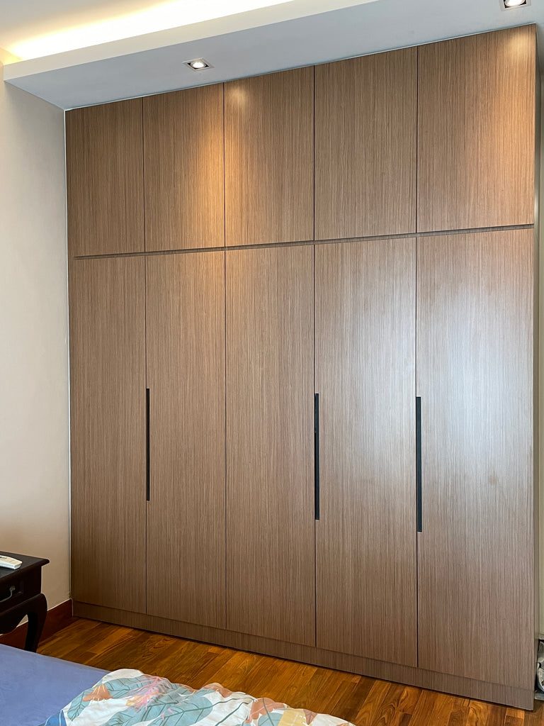 A full height custom made wardrobe in woodgrain laminate and with recess groove handle in the master bedroom.